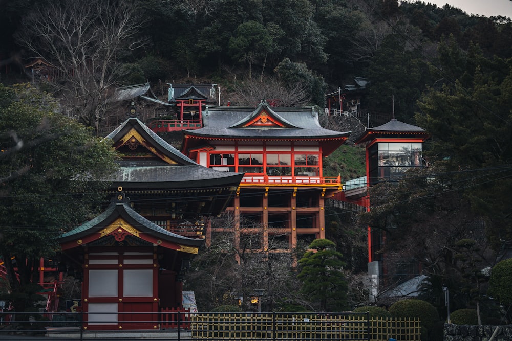 a red and yellow building sitting on top of a lush green hillside