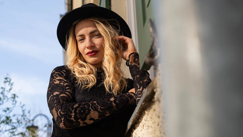 Sugar Mommy sofisticada en vestido negro y sombrero