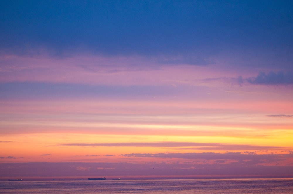 a boat is out on the water at sunset