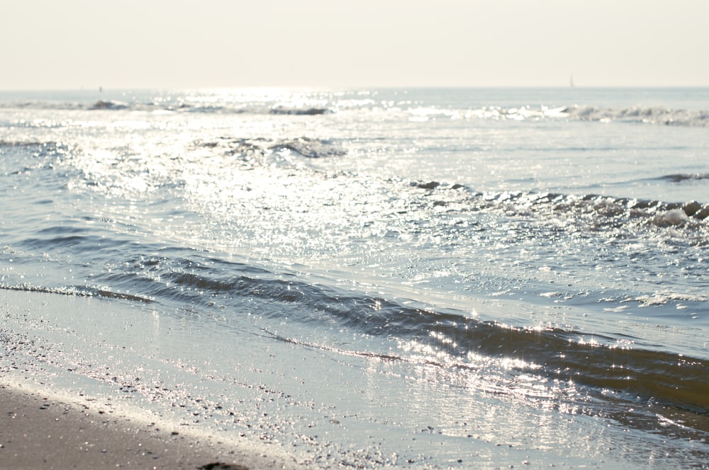 a person walking on the beach with a surfboard