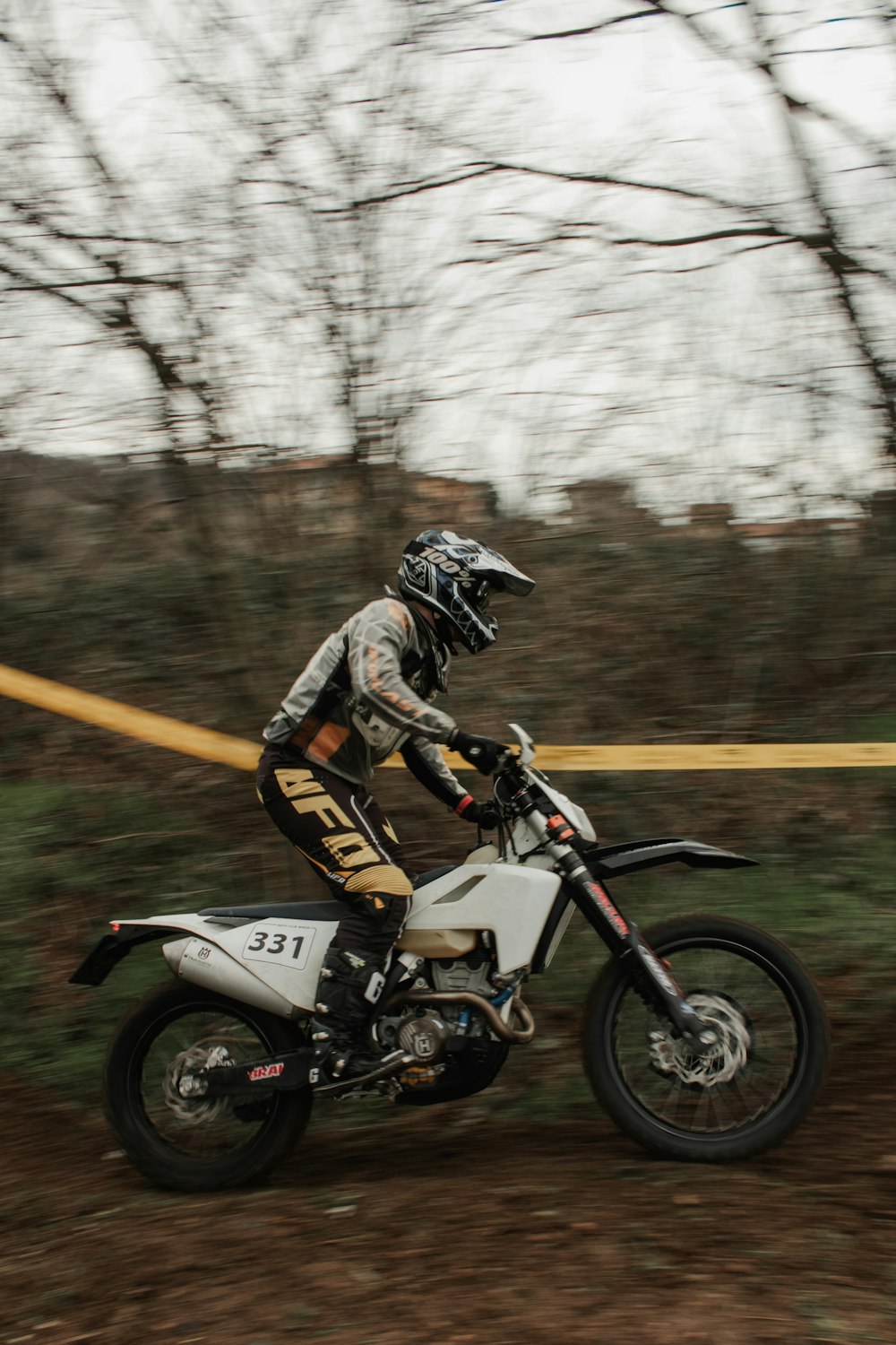 a man riding a dirt bike down a dirt road