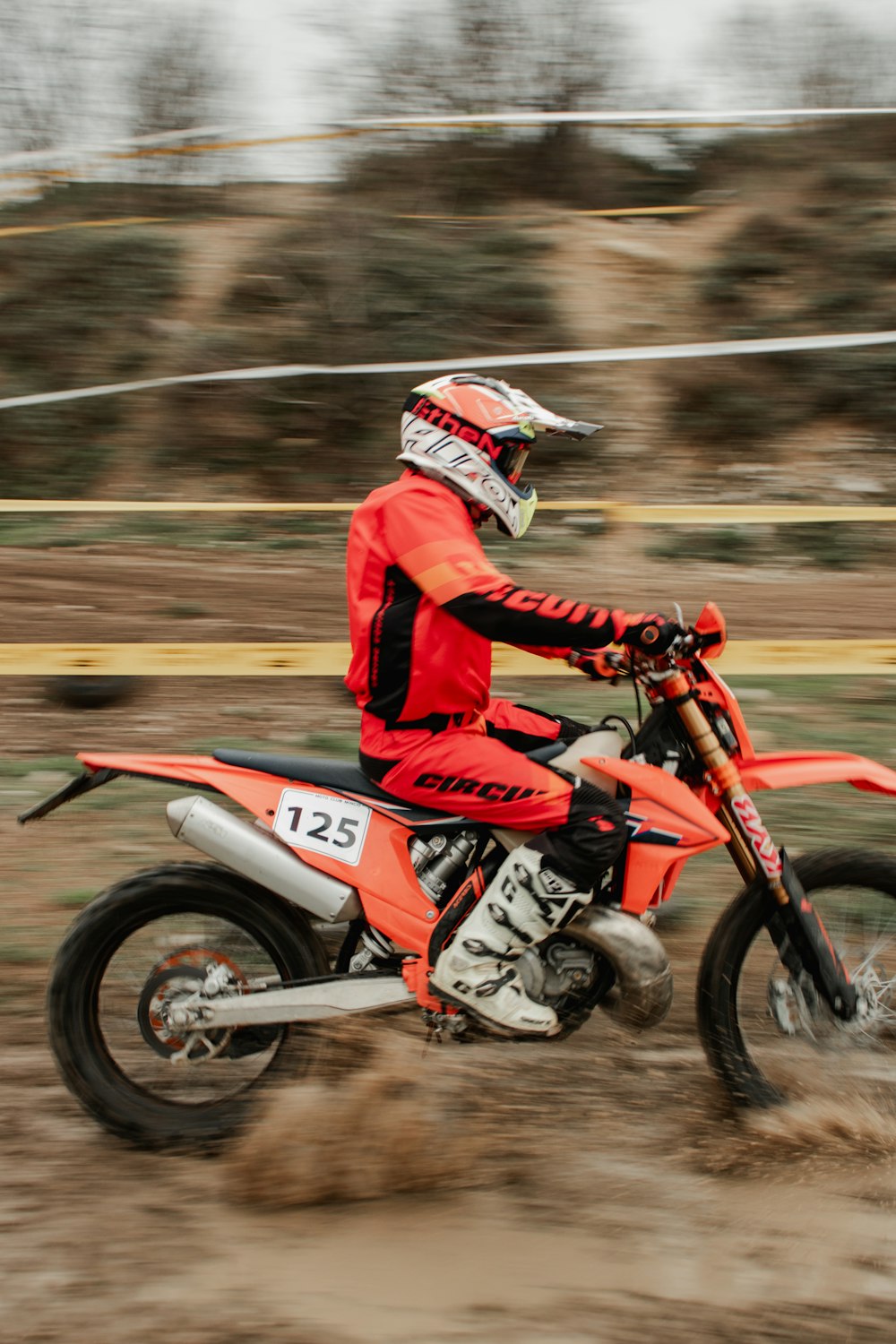 a man riding a dirt bike on top of a dirt field