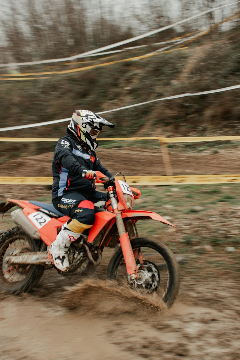 Un homme conduisant une moto tout-terrain sur le dessus d’un champ de terre