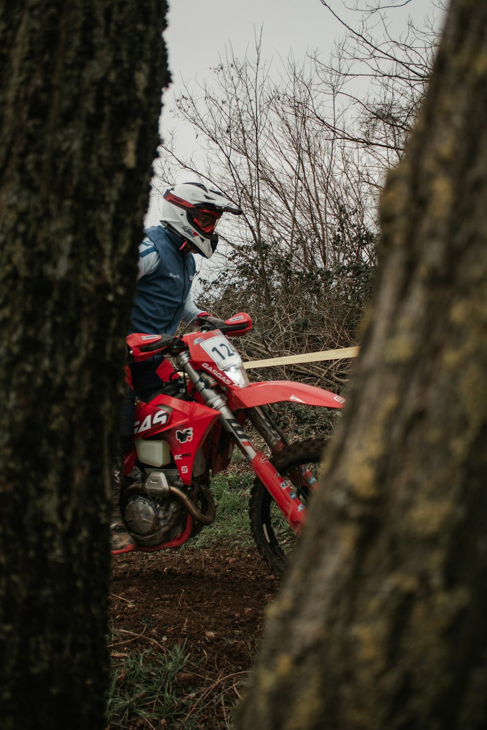 a man riding a dirt bike through a forest