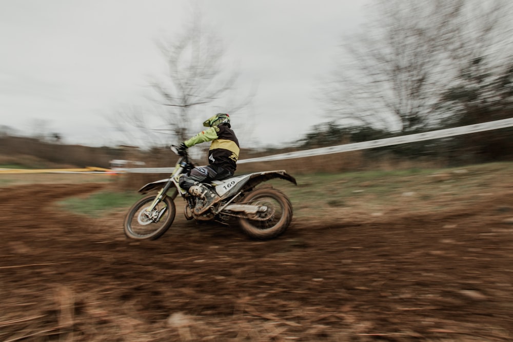 une personne conduisant une moto tout-terrain sur un chemin de terre