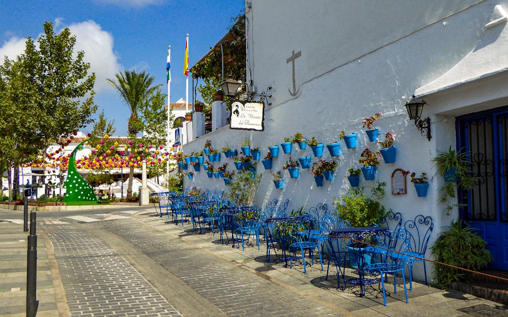a row of blue chairs sitting next to a white building