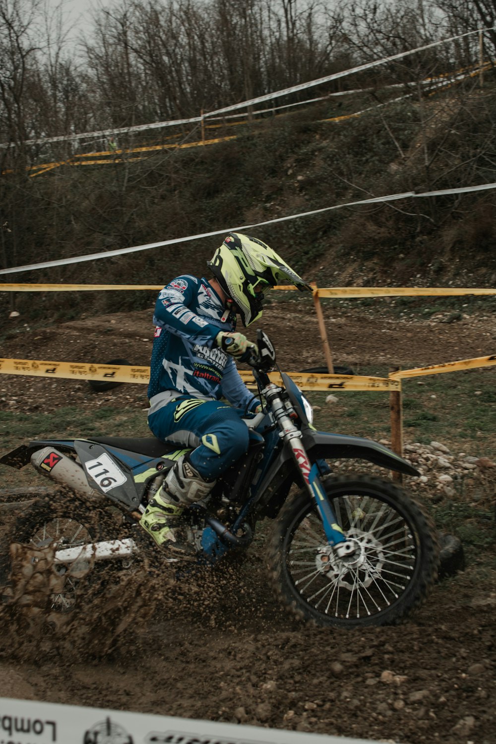 a person riding a dirt bike on a muddy track