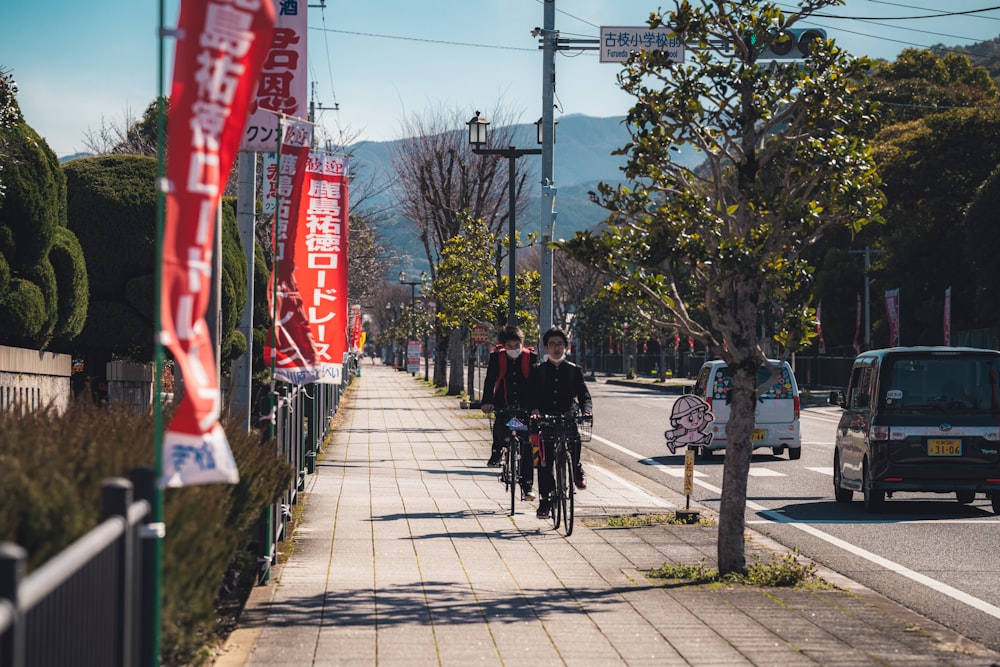 a couple of people riding bikes down a street