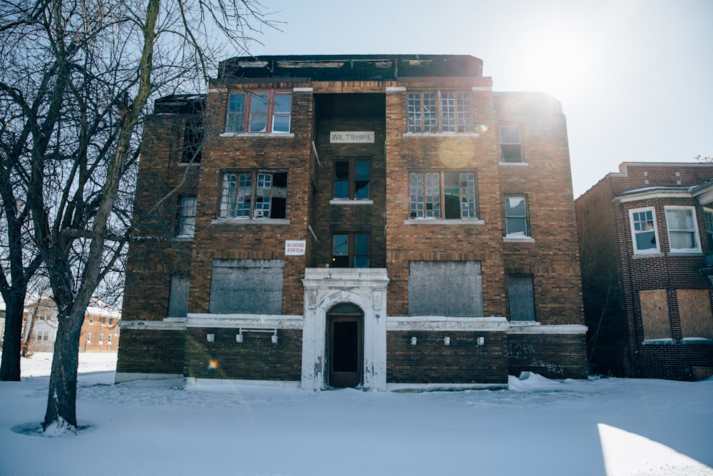 an old brick building with a tree in front of it