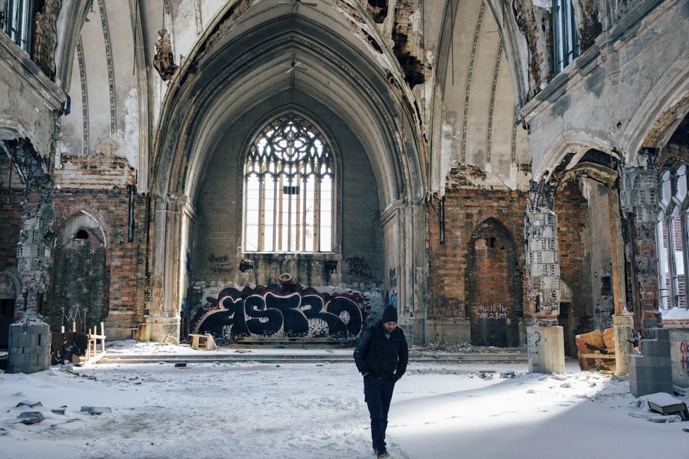 a person standing in an old building with graffiti on the walls