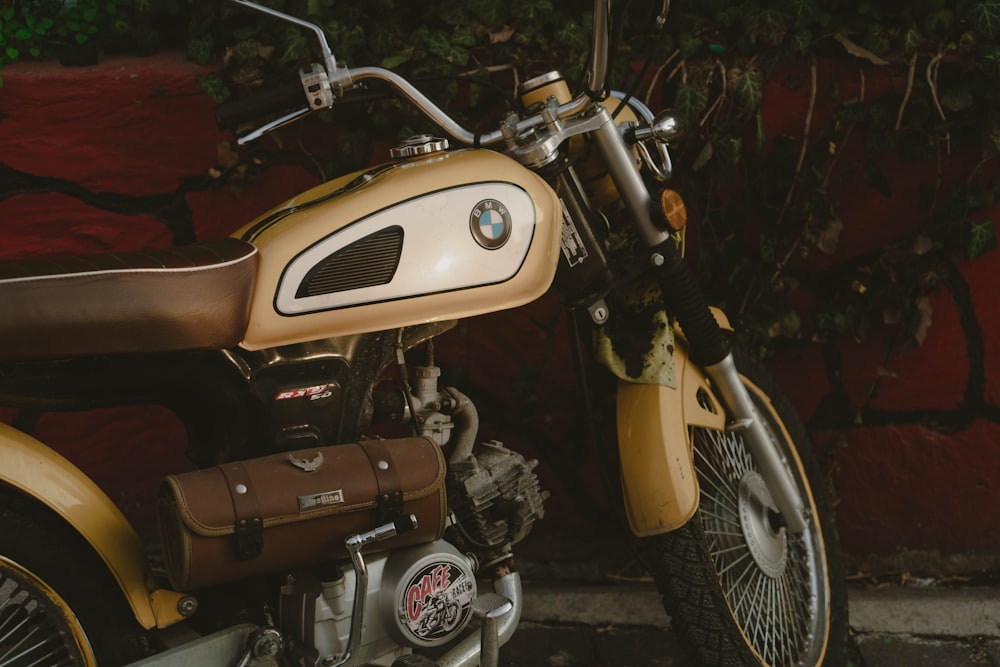 a yellow motorcycle parked next to a red wall