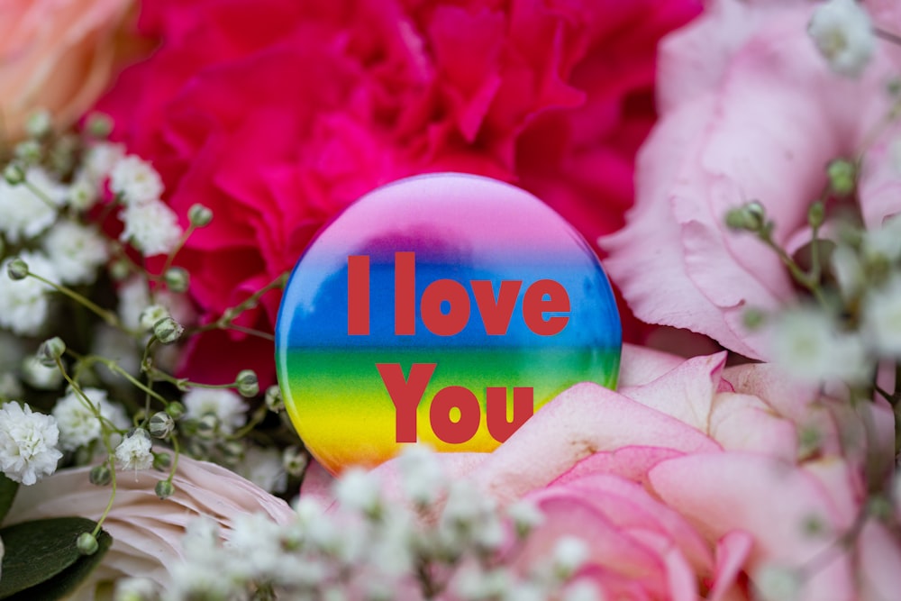 a button that says i love you surrounded by flowers