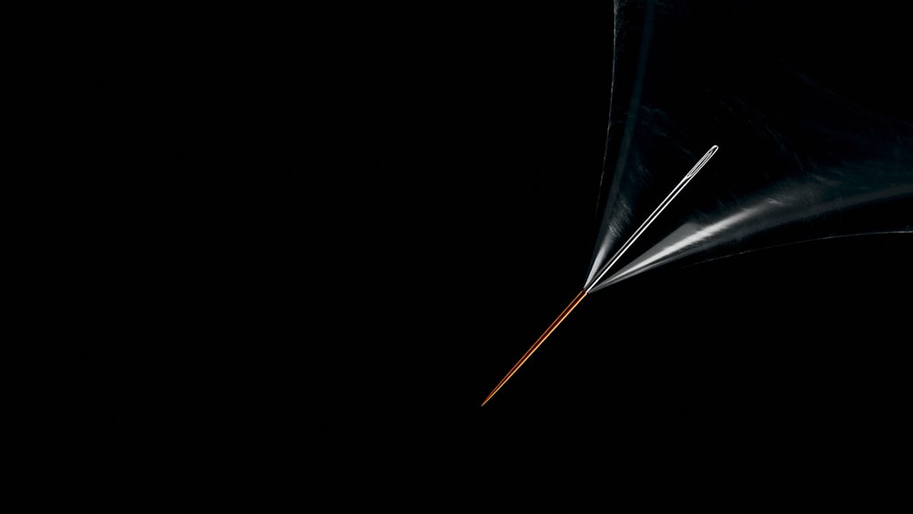 a black background with an orange and white umbrella