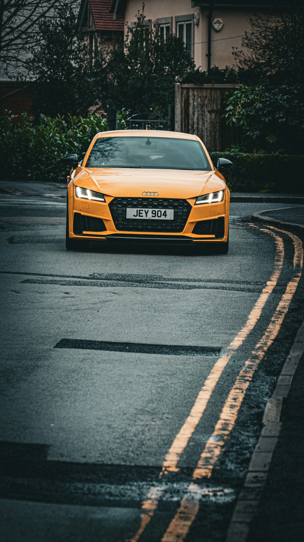 a yellow car is driving down the street