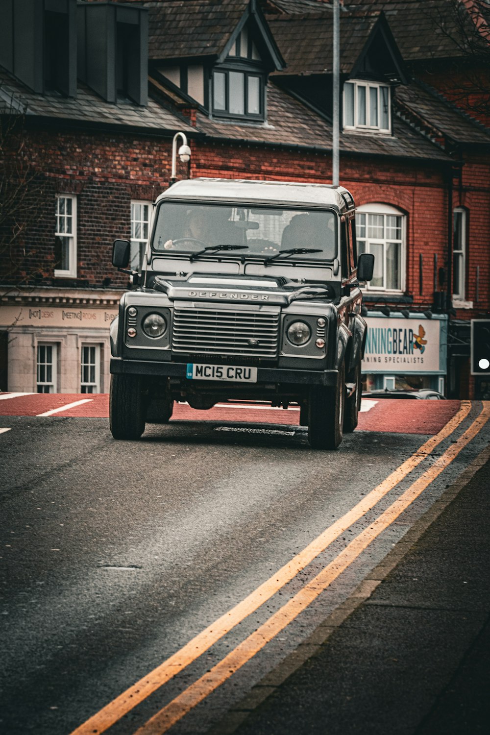 a black truck driving down a street next to tall buildings