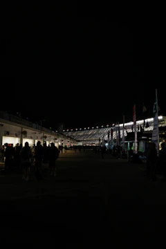 a crowd of people standing around a building at night