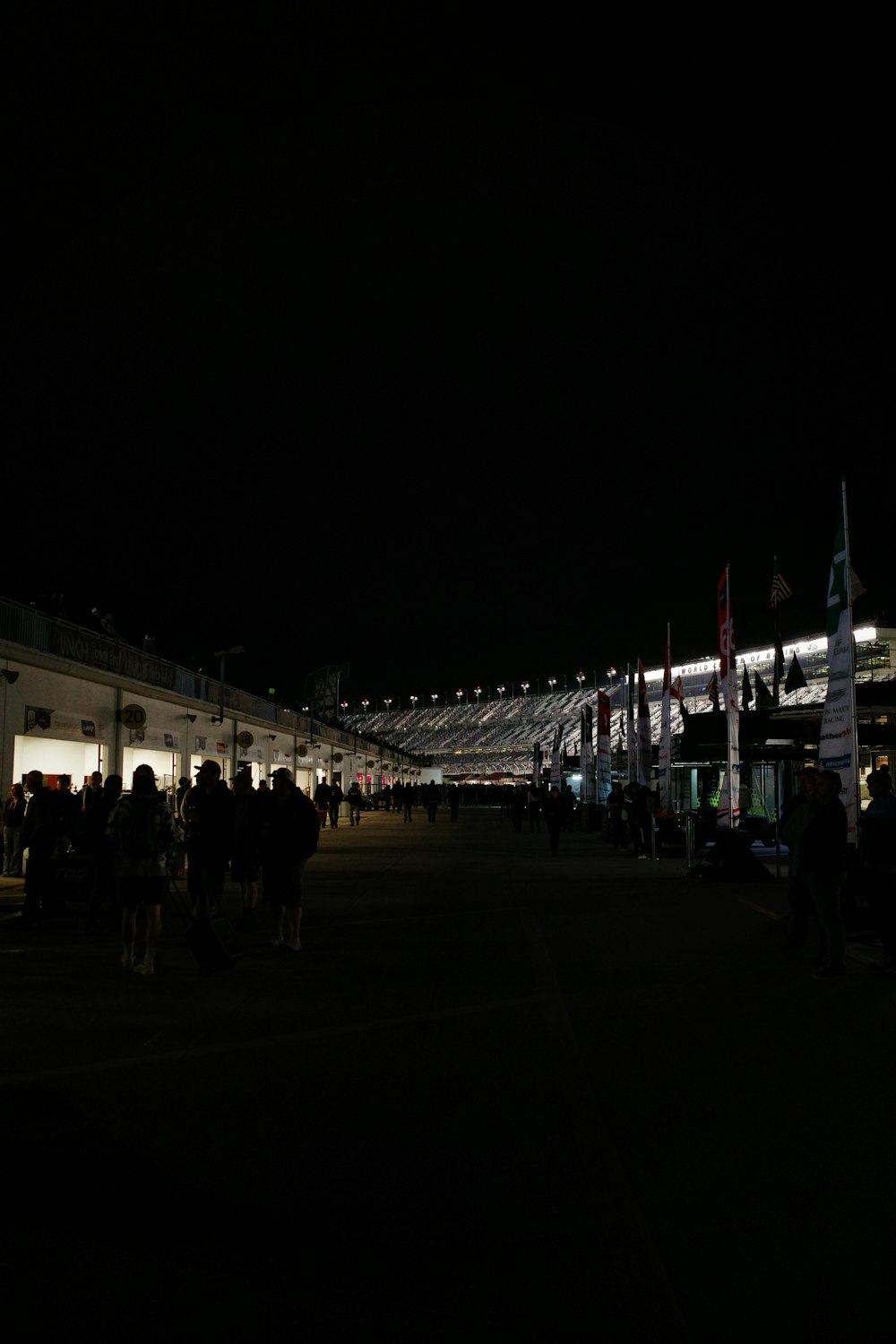 a crowd of people standing around a building at night