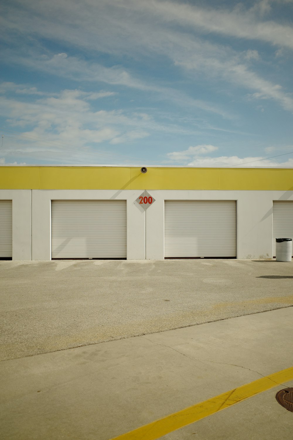 a yellow and white building with two garages