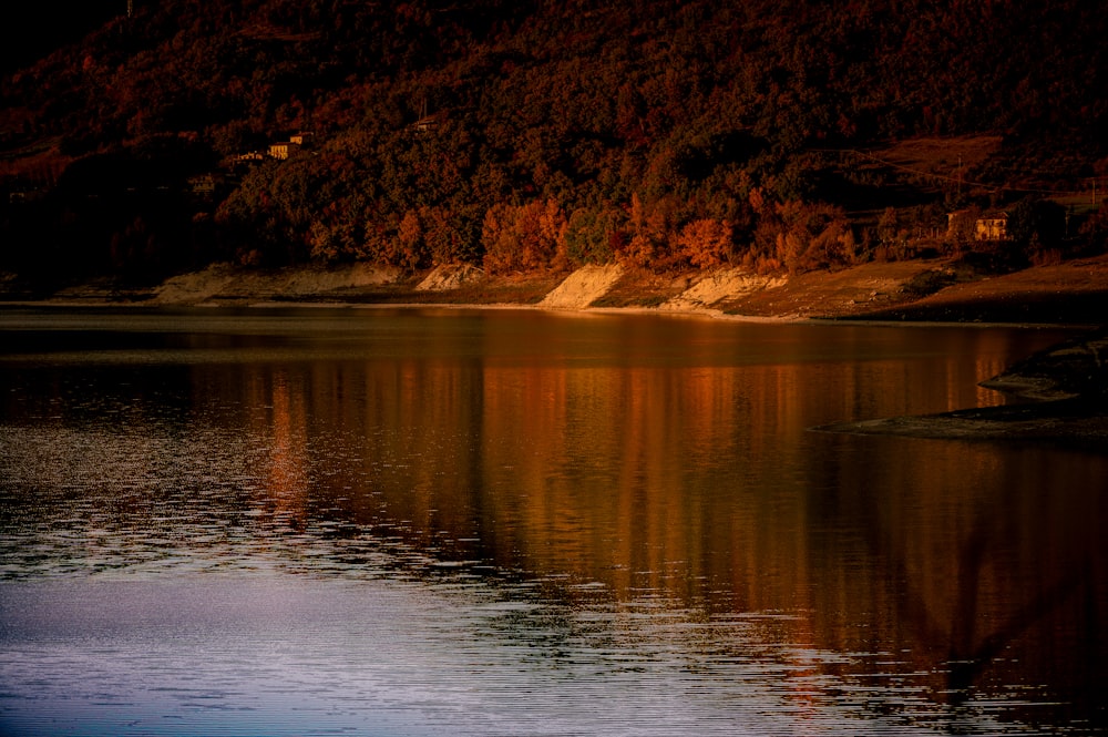 a body of water with a hill in the background