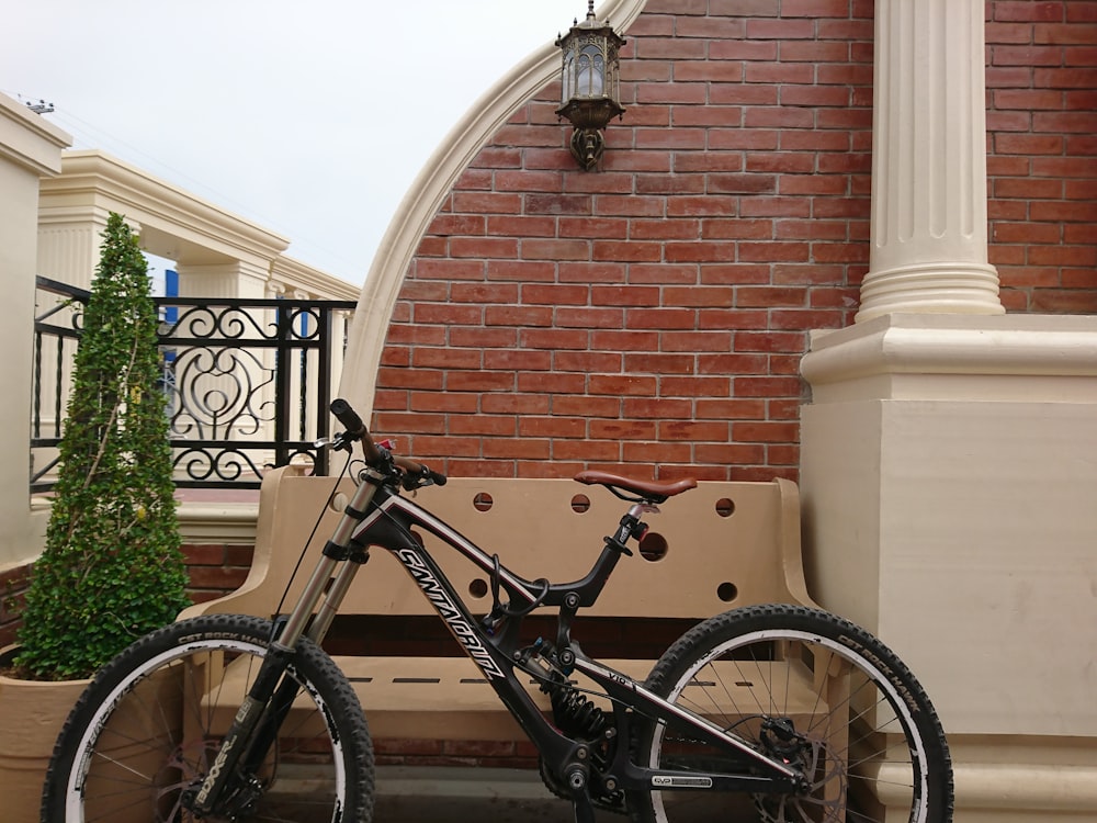 a bicycle parked next to a bench in front of a building