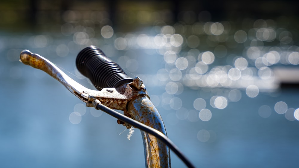 a close up of a bike handle with water in the background