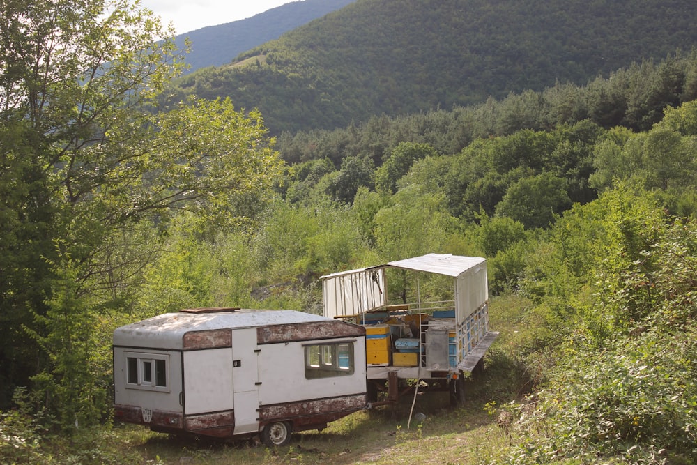 an old trailer sits in the middle of a forest