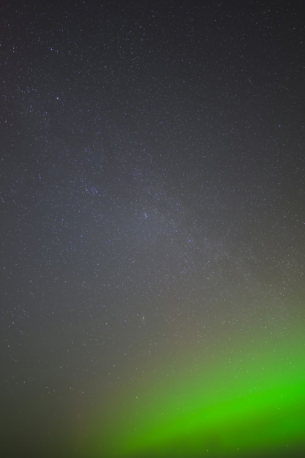 a green and black sky with some stars
