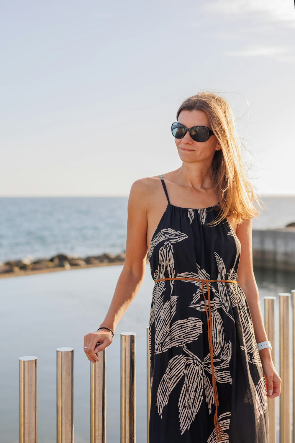 a woman in a black and white dress and sunglasses