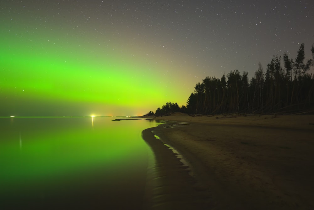 a green and black aurora over a body of water