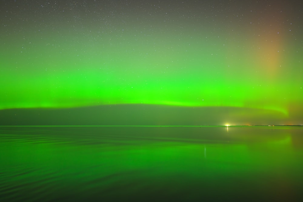 a bright green aurora bore over a body of water