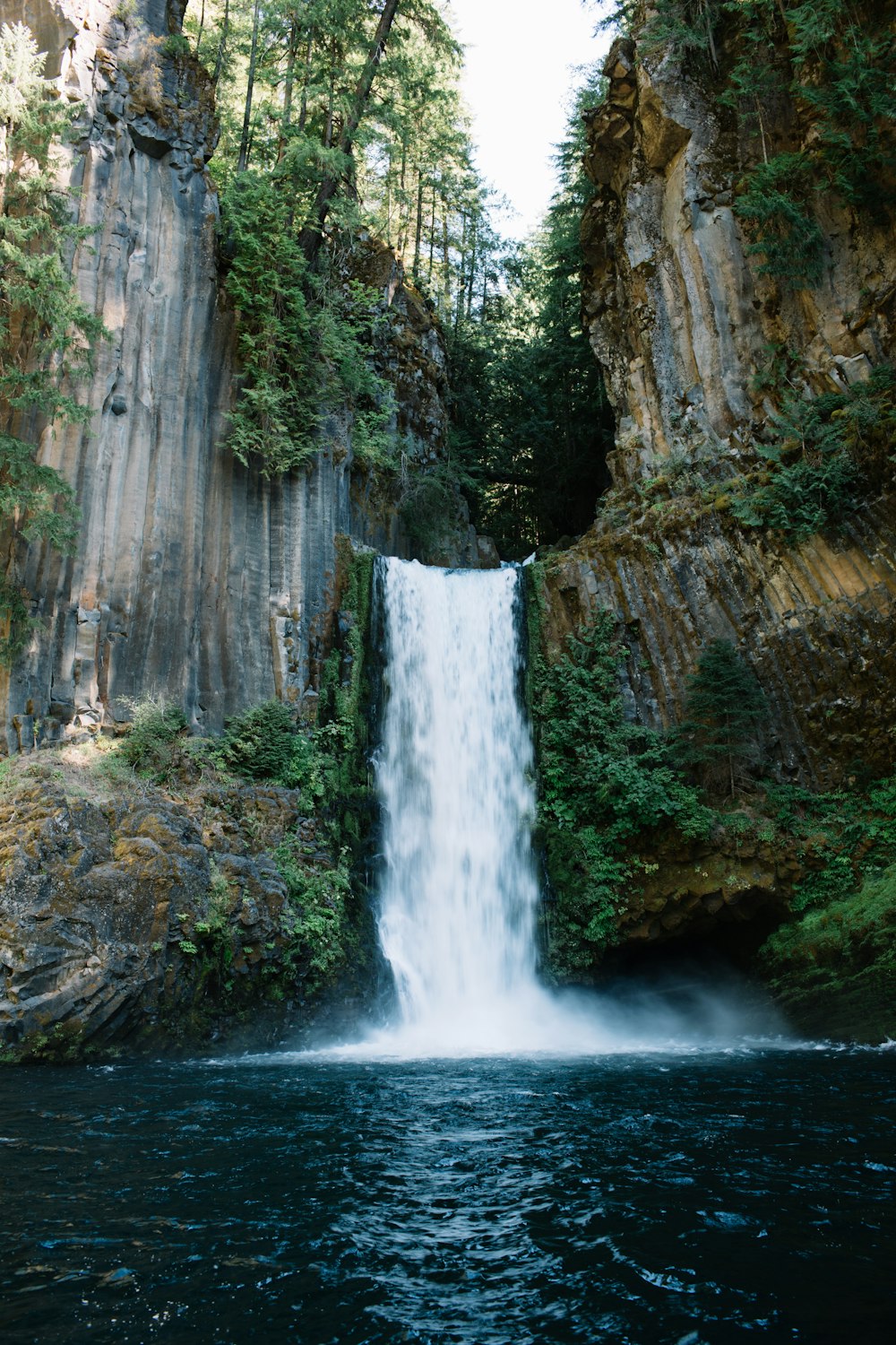 a waterfall with a waterfall cascading down it's side