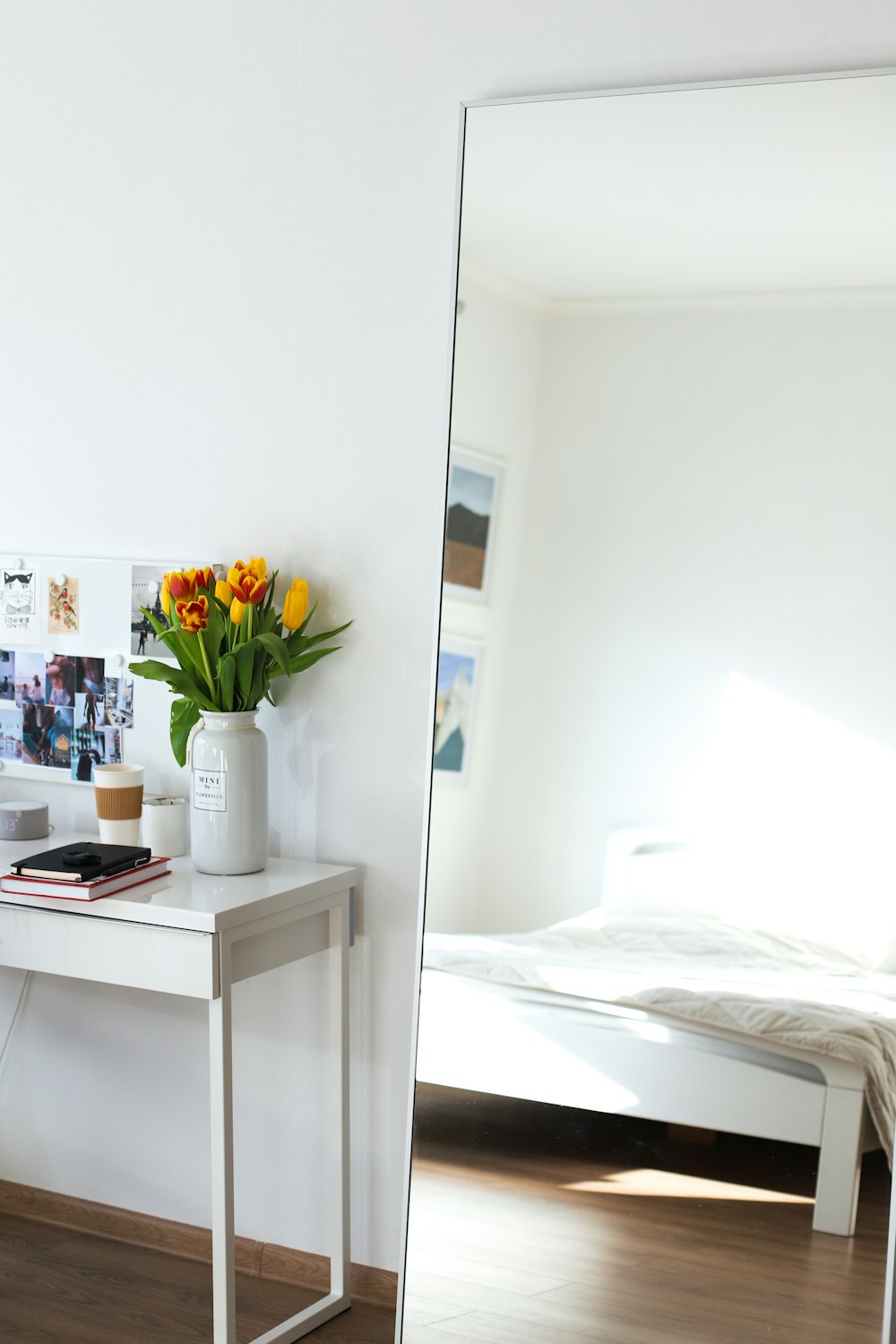 a white desk with a vase of flowers on top of it