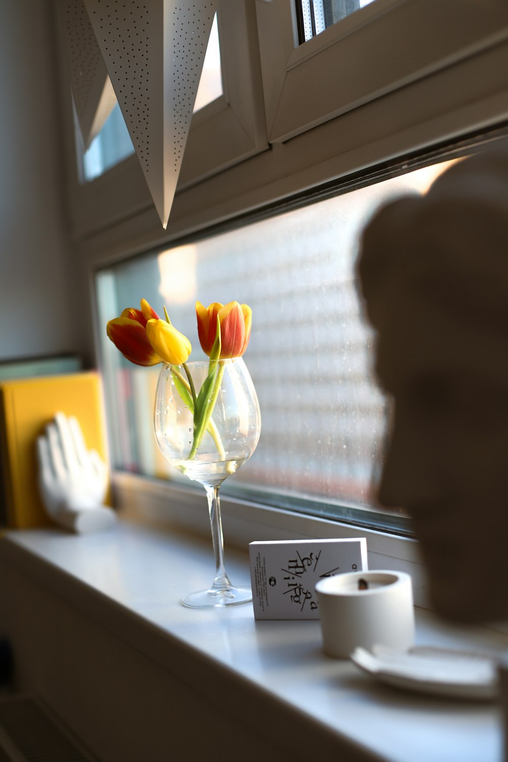 a vase with flowers sitting on a window sill