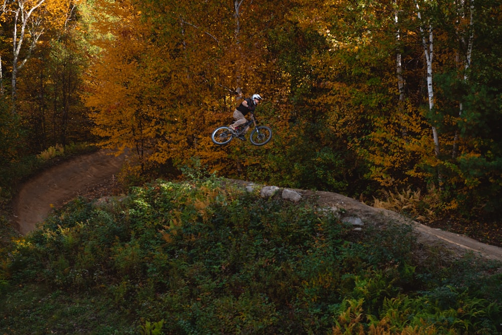 a person on a bike jumping over a hill