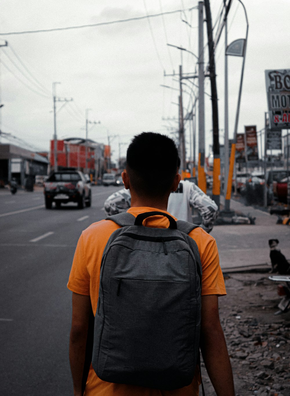 a man with a backpack walking down a street