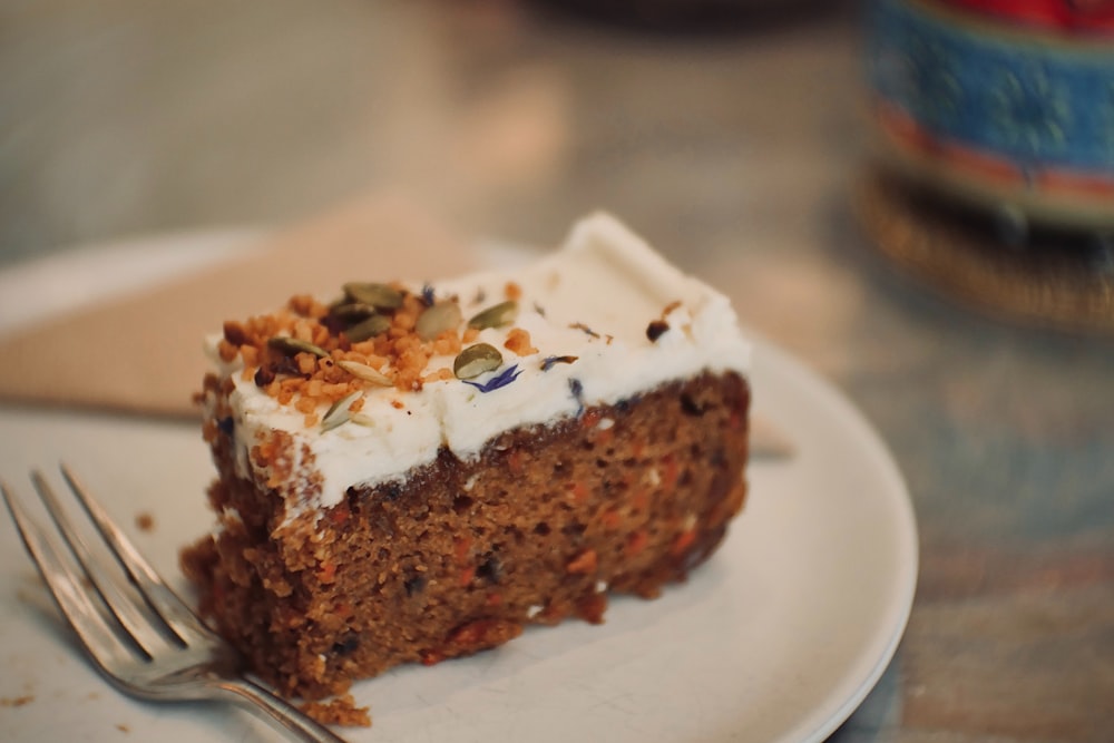 a piece of carrot cake on a plate with a fork