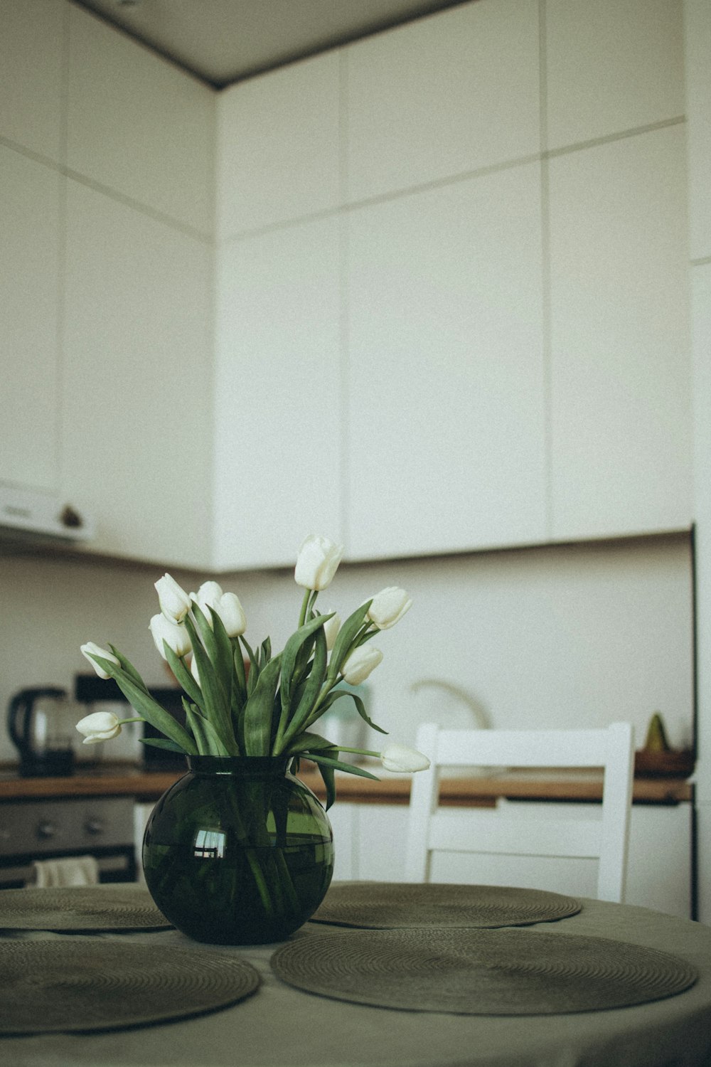 a vase filled with white flowers sitting on top of a table