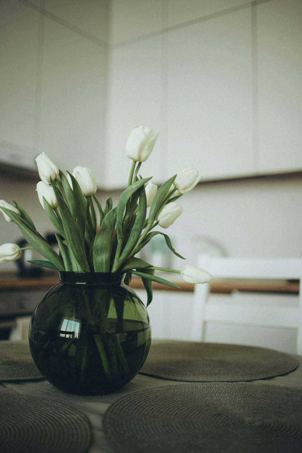 a vase filled with white flowers sitting on top of a table