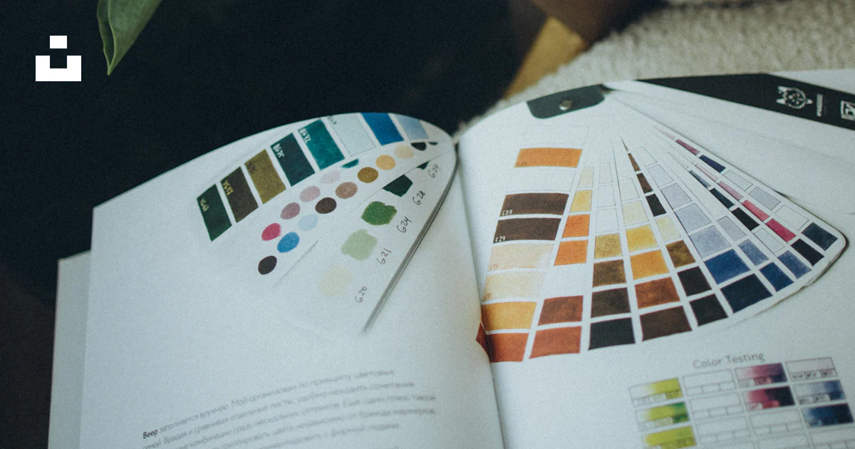 A book opened to a color guide next to a vase of flowers photo – Free ...