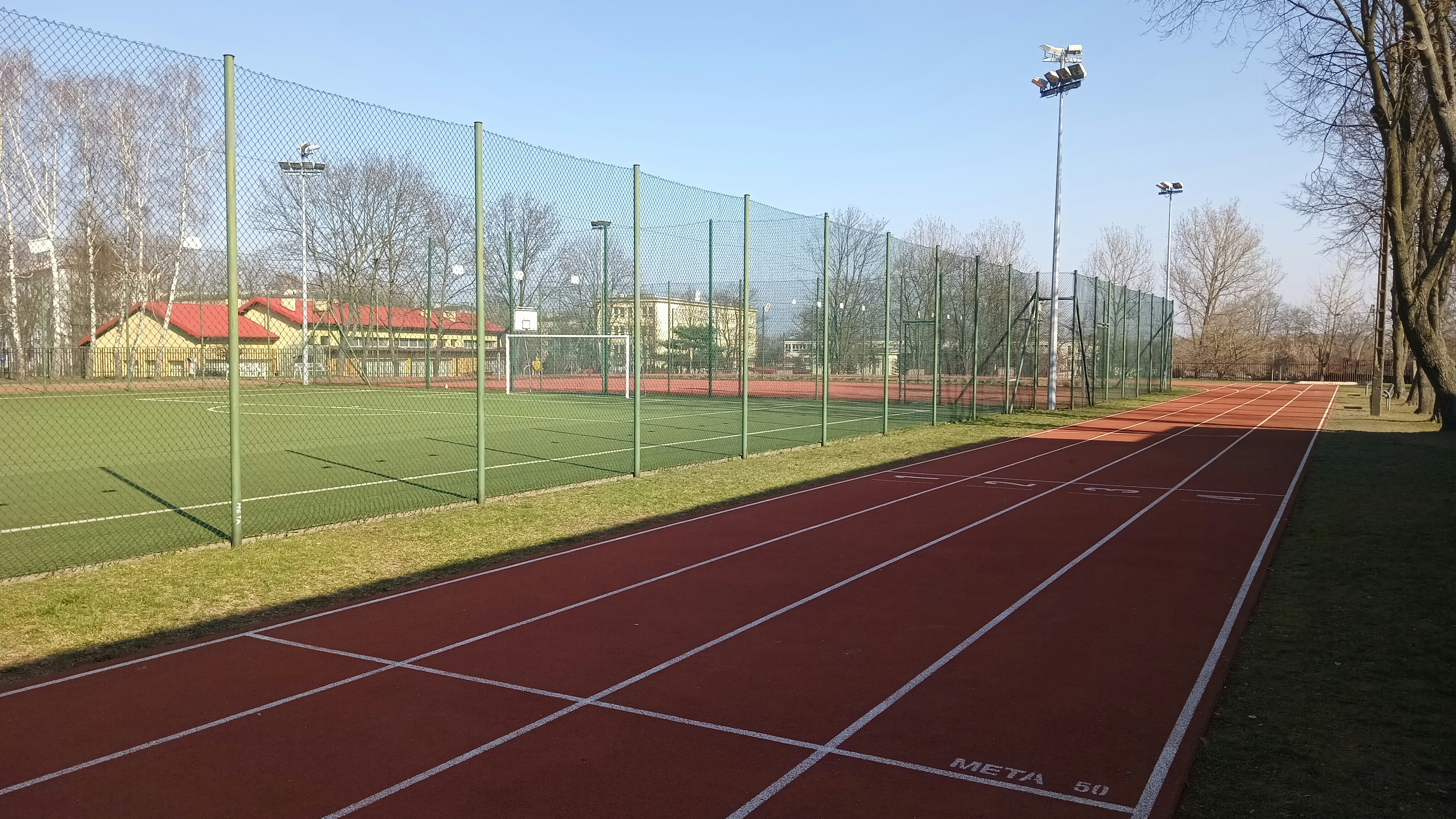 Athletics stadium with dramatic lighting, running track visible, competitive sports atmosphere