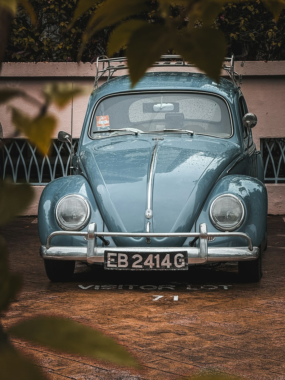 a blue vw bug parked in front of a building