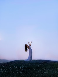 a woman standing on top of a lush green field