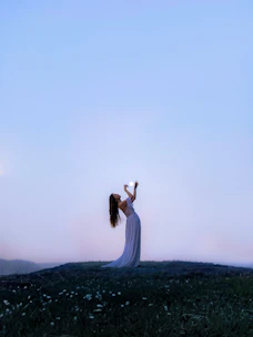 a woman standing on top of a lush green field