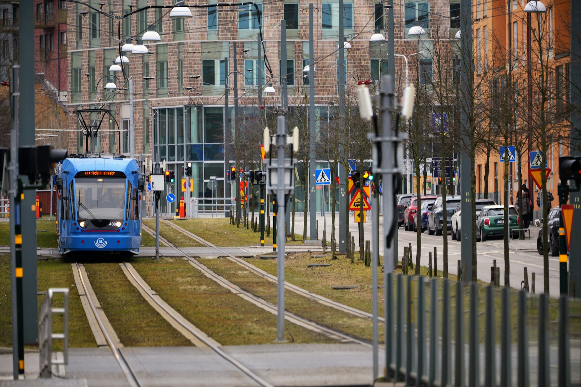 a blue bus driving down a street next to tall buildings