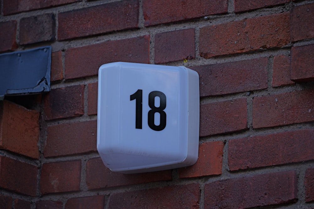 a white clock mounted to a brick wall
