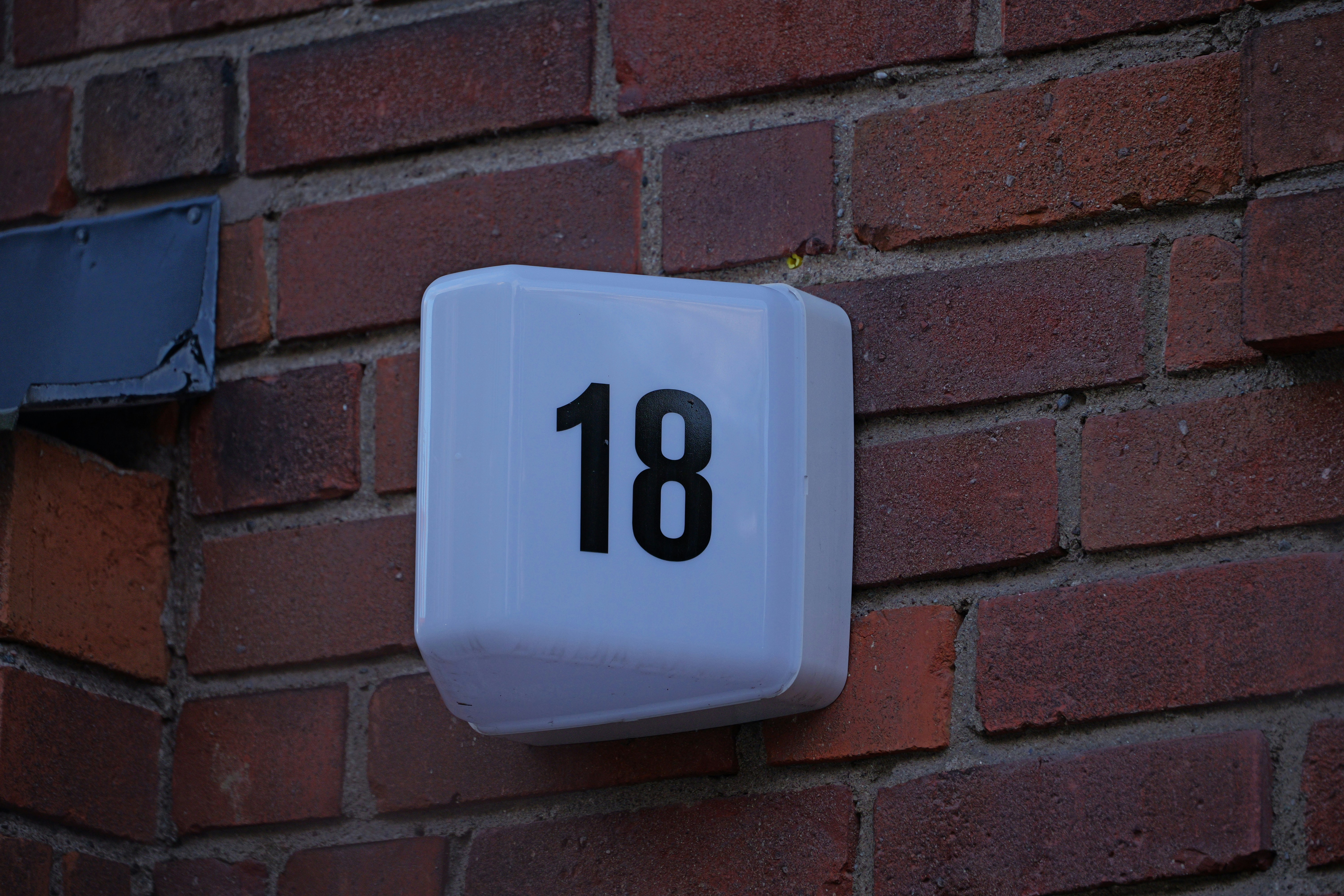 a white clock mounted to a brick wall