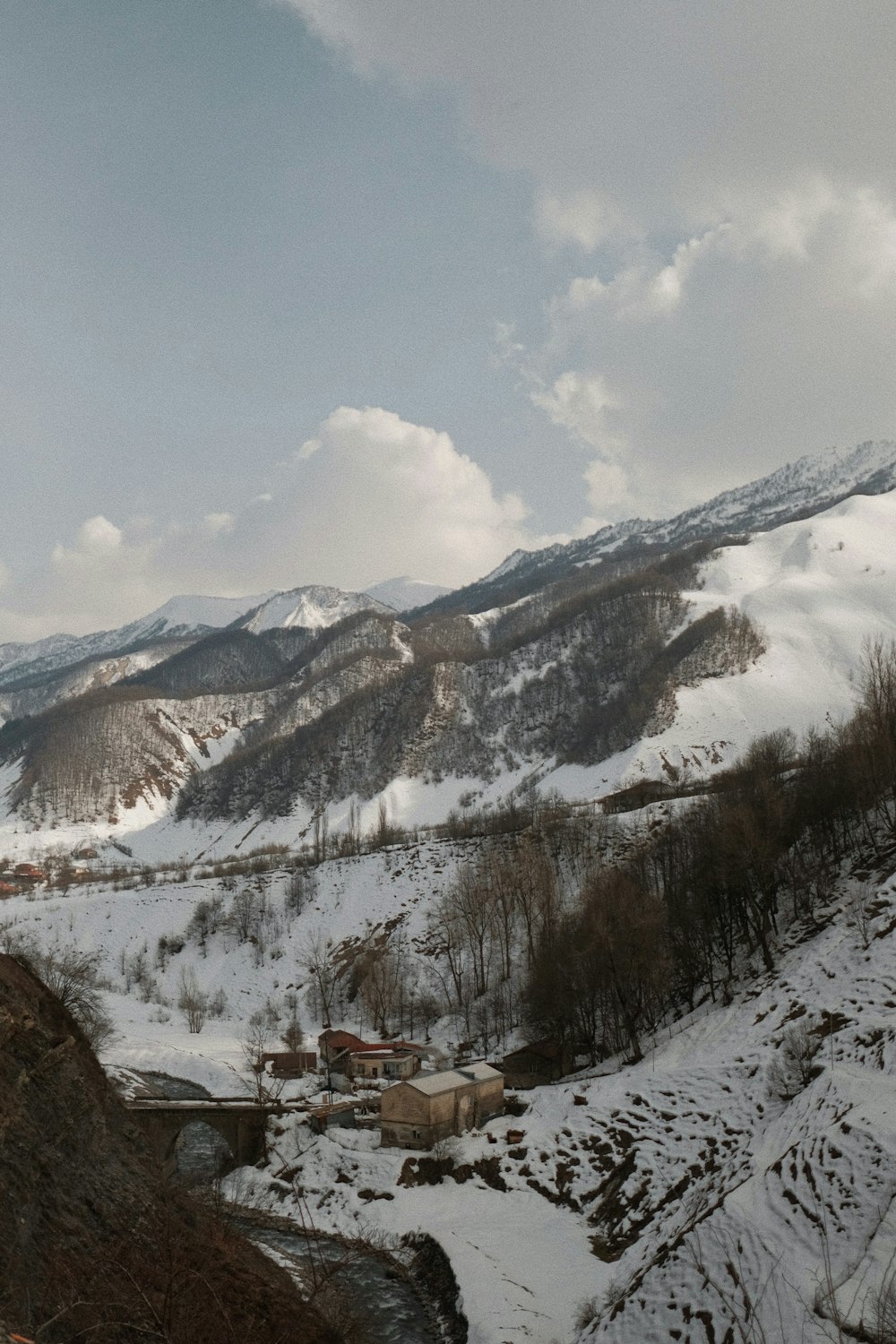 a view of a snowy mountain with a bridge in the foreground