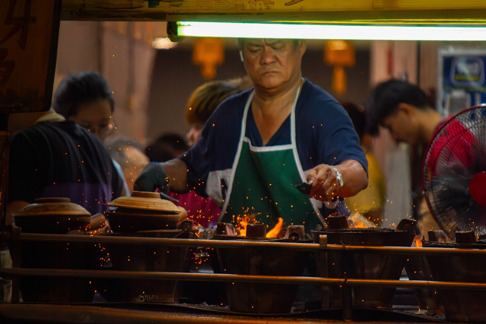 a woman in an apron is cooking food on a grill