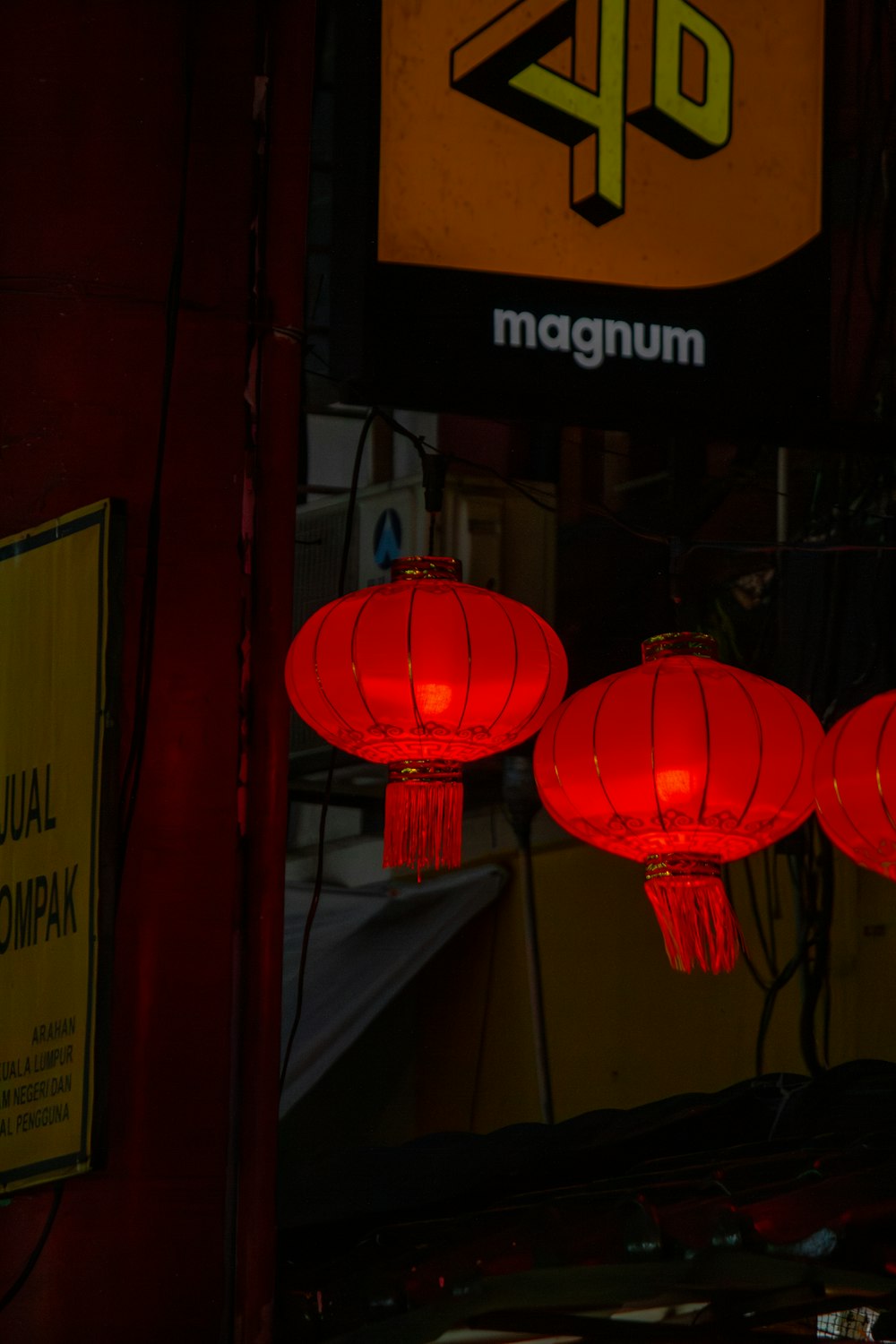 a group of red lanterns hanging from the side of a building