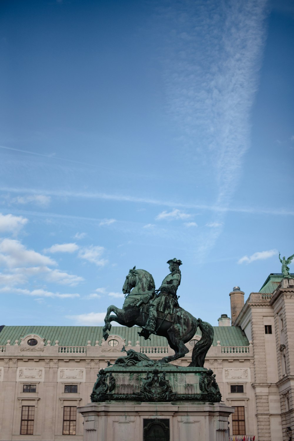 a statue of a man on a horse in front of a building